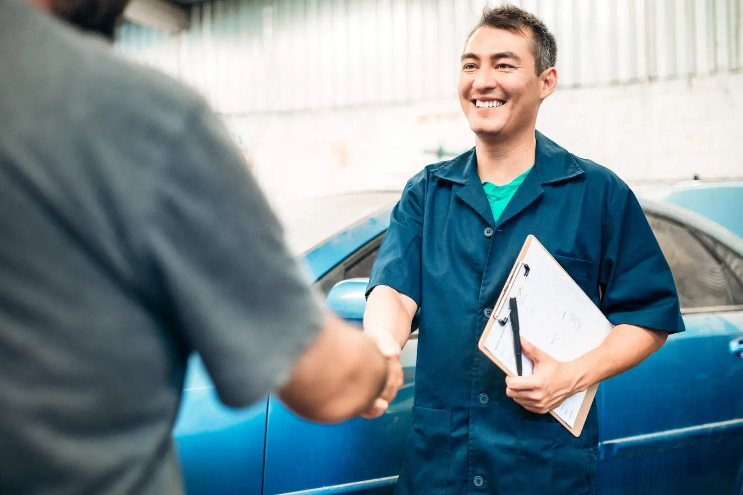 Windscreen repair technician shaking hands with a customer
